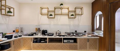 A modern kitchen with built-in appliances, wooden cabinetry, and a speckled floor.