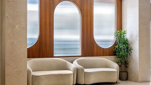 Ein modernes Interieur mit zwei Sofas, einem großen Fenster mit Aussicht und einer Topfpflanze.