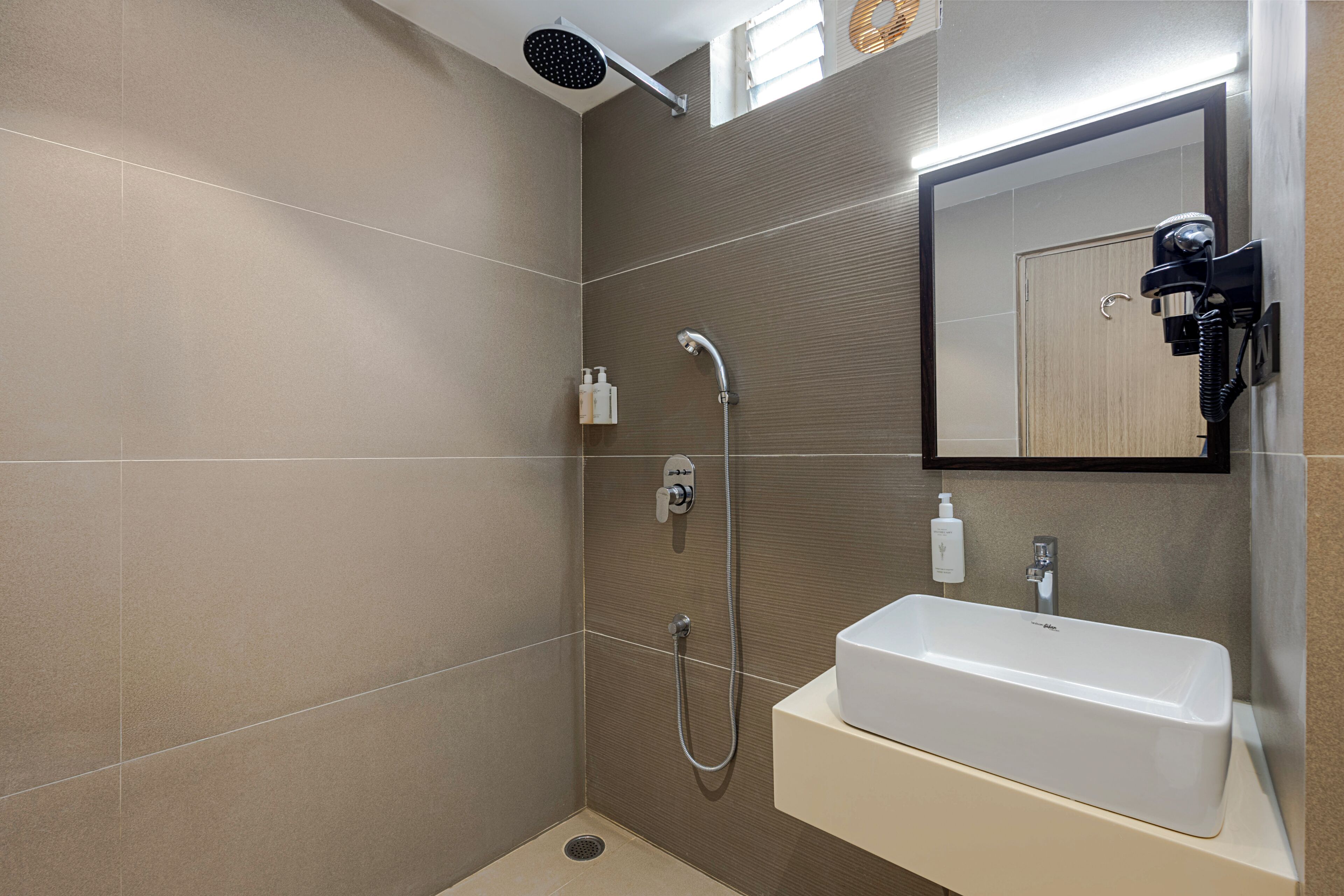 A modern bathroom with a shower, a sink, and a mirror.