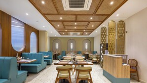 Ein Restaurant mit Sitzecken, Tischen und einer Rezeption.