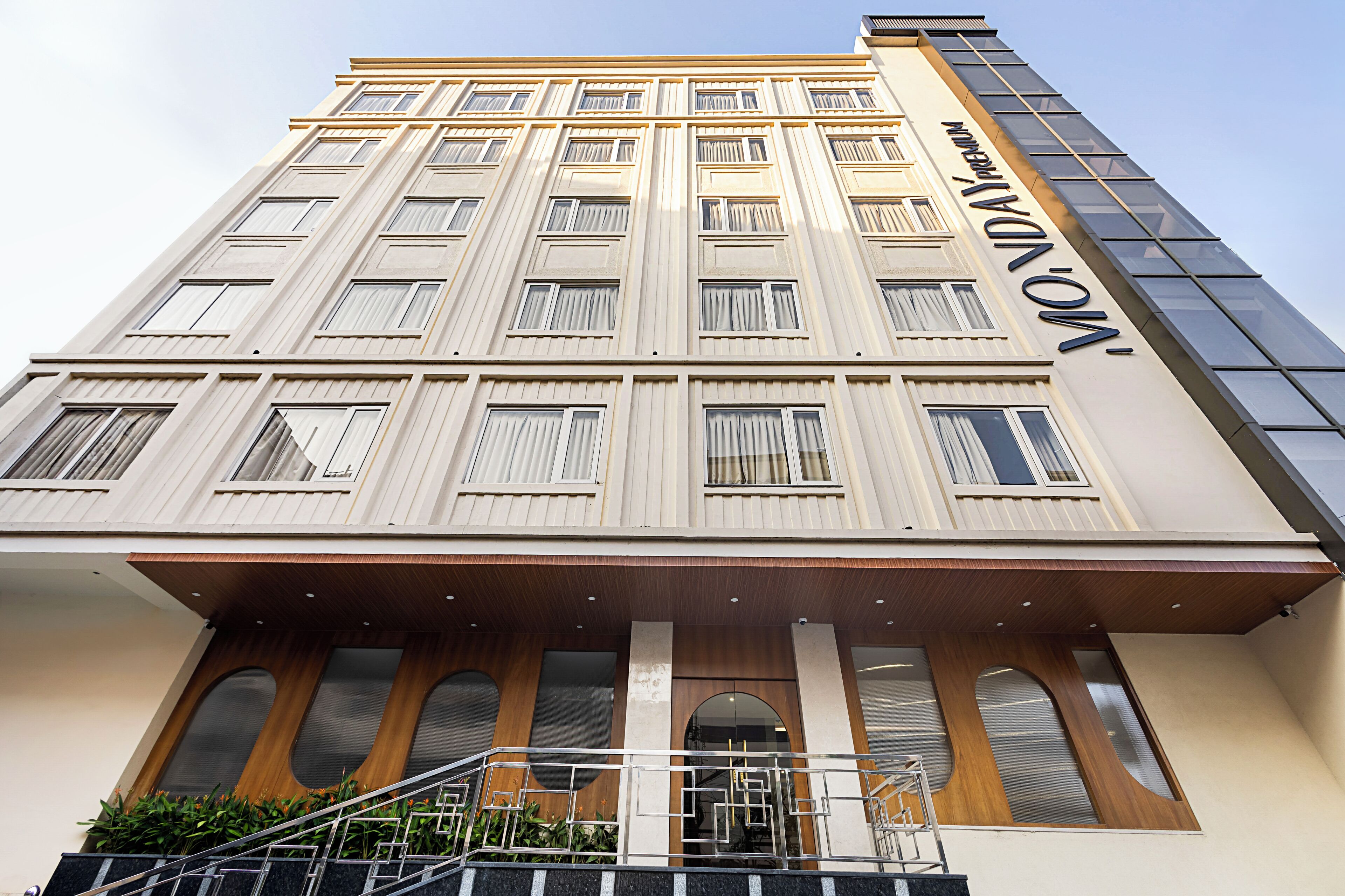 Un hôtel à plusieurs étages doté d’une façade moderne, de grandes fenêtres et d’une entrée imposante avec une rampe d’accès.