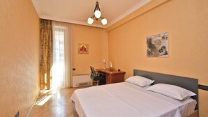 A hotel room with a bed, desk, chair, and a ceiling light fixture. - North ave apartment by Luxe Group HH106 (Yerevan)