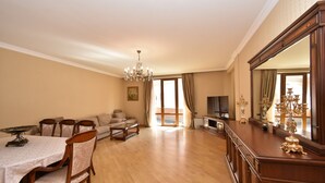 A spacious living room with a dining area, a sofa set, a chandelier, and a large mirror. - North ave apartment by Luxe Group HH106 (Yerevan)