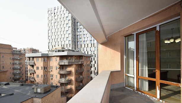 A balcony with a view of adjacent buildings, including a high-rise with a grid-like facade. - North ave apartment by Luxe Group HH106 (Yerevan)