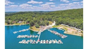 An aerial view of a marina with boats docked, surrounded by forested hills. - Ahrens Rd Ranch (Parksville)