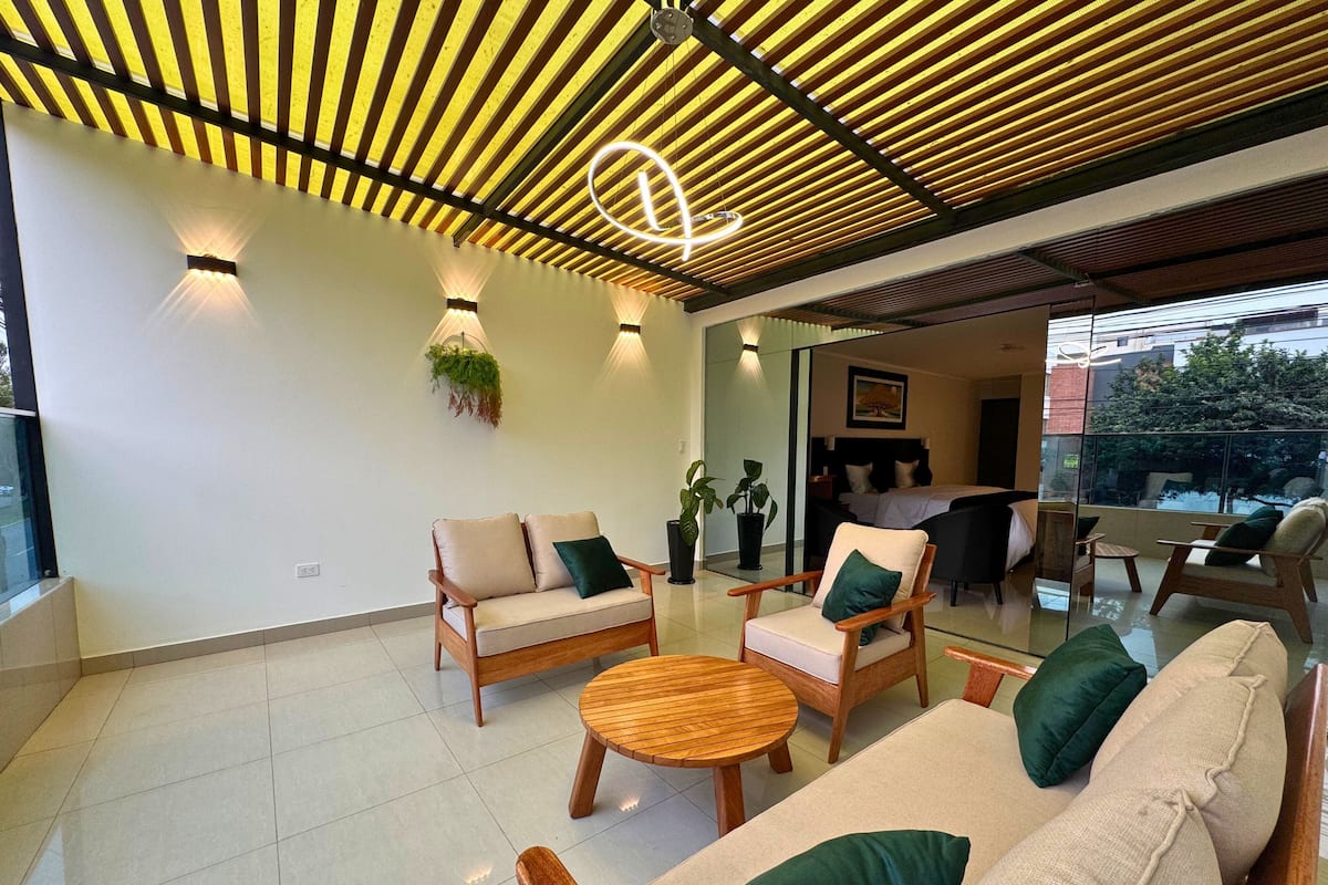 Un intérieur moderne comprenant un ensemble de canapés, des chaises en bois, une table ronde en bois et un comptoir d’accueil.