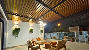A modern interior with a sofa and chairs, a coffee table, and hanging plants. - City Tower Hotel (Santiago de Surco)