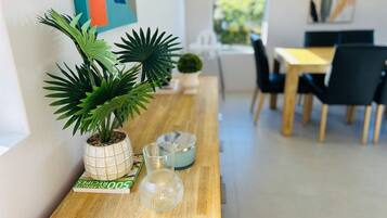 A wooden table with a potted plant, a glass vase, and a book.