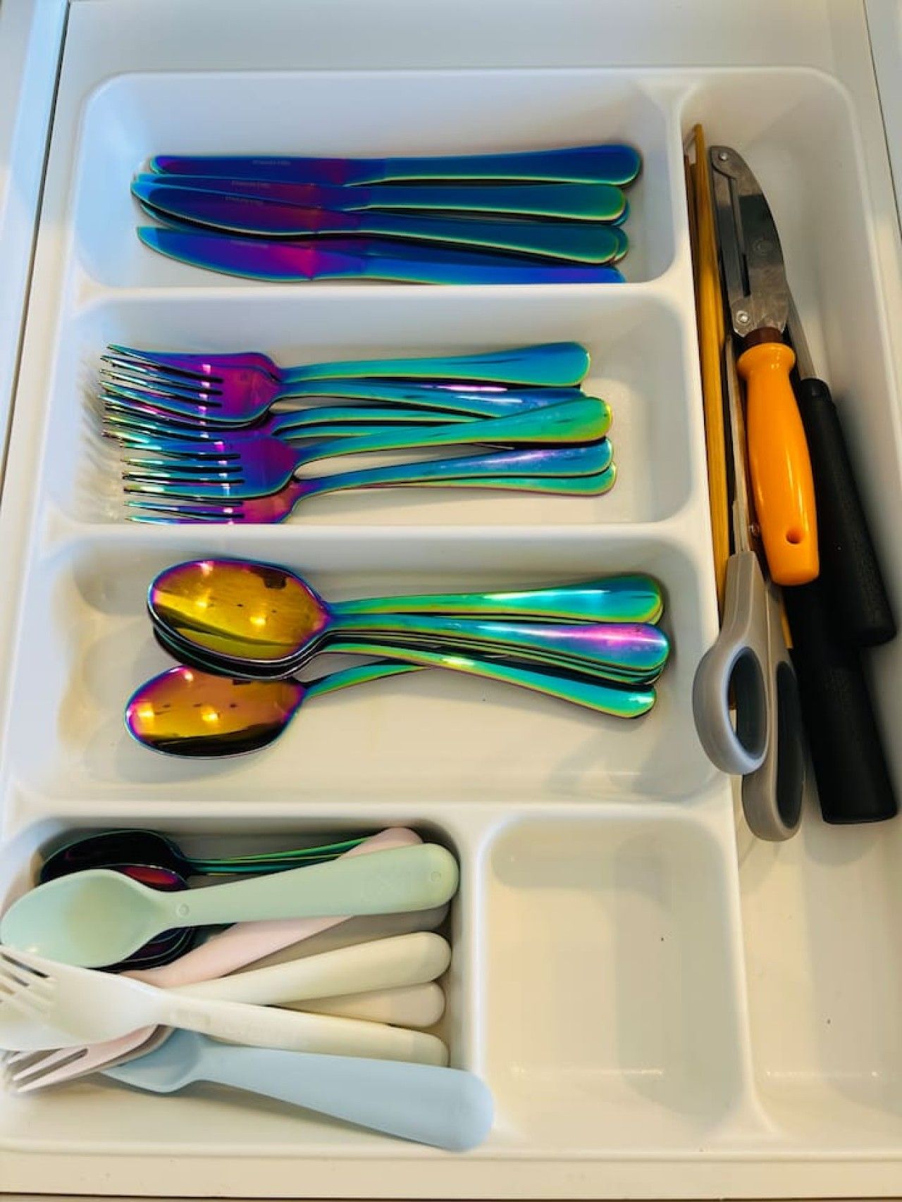 A tray with various utensils including forks, spoons, and a knife.