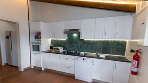 Een moderne keuken met witte kastjes, een roestvrijstalen fornuis, een magnetron en een vaatwasser.
