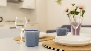 A dining table with a wine glass, a blue mug, and a white plate. - AuGuStea-The Nest of Sannicandro (Bari)