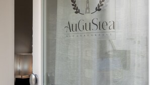 A door with a frosted glass panel displaying the logo and name 'AuGuStea Bed & Breakfast'. - AuGuStea-The Nest of Sannicandro (Bari)