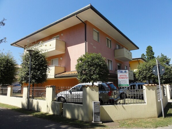 Un immeuble à plusieurs étages sur lequel est apposée une enseigne publicitaire pour des services immobiliers.