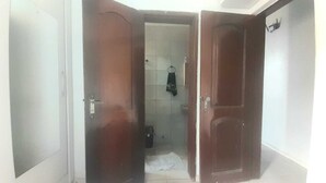 A room with a wooden door, a tiled shower area, and a visible towel rack. - Apartamento em Belém no período da COP 30 (Belem)