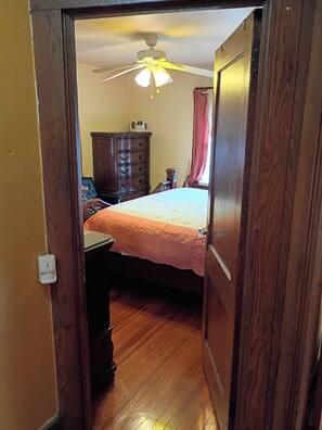 Ein Schlafzimmer mit Bett, Schminktisch und Deckenventilator.