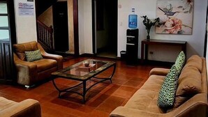 Amplia sala de estar con techo alto, una escalera y un balcón.