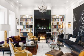 A spacious living room with a fireplace, bookshelves, and comfortable seating.