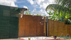Una piscina con cerca de madera y un pequeño jardín.