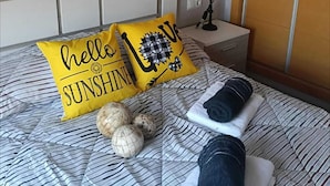 A neatly made bed with striped bedding, two pillows with 'hello sunshine' text, a lamp, and a mirror on the wall. - Luxury penthouse with swimming pool, jacuzzi and gym near the spa of archena (MC)