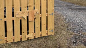 A wooden gate with a sign reading "HONEYCOMB HIDEAWAY" and a bee illustration.