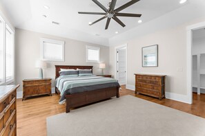 A bedroom with a large bed, two nightstands, a ceiling fan, and a wardrobe. - Luxurious 6 Bedroom House Across From Beach! (Isle of Palms)