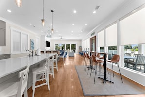 Een moderne keuken met een centraal eiland, barstoelen en een eetgedeelte met uitzicht.