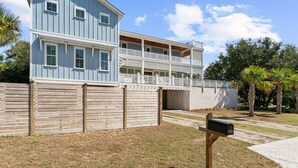Un bâtiment à deux étages doté d’un balcon, d’une clôture en bois et d’une boîte aux lettres.