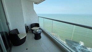A balcony with two wicker chairs and a small table, overlooking a calm sea. - Apartamentos Palmetto Eliptic ICDI (Cartagena)