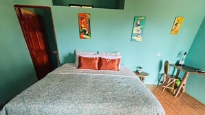 Une pièce avec un lit, un plancher en bois et un bureau avec des chaises.