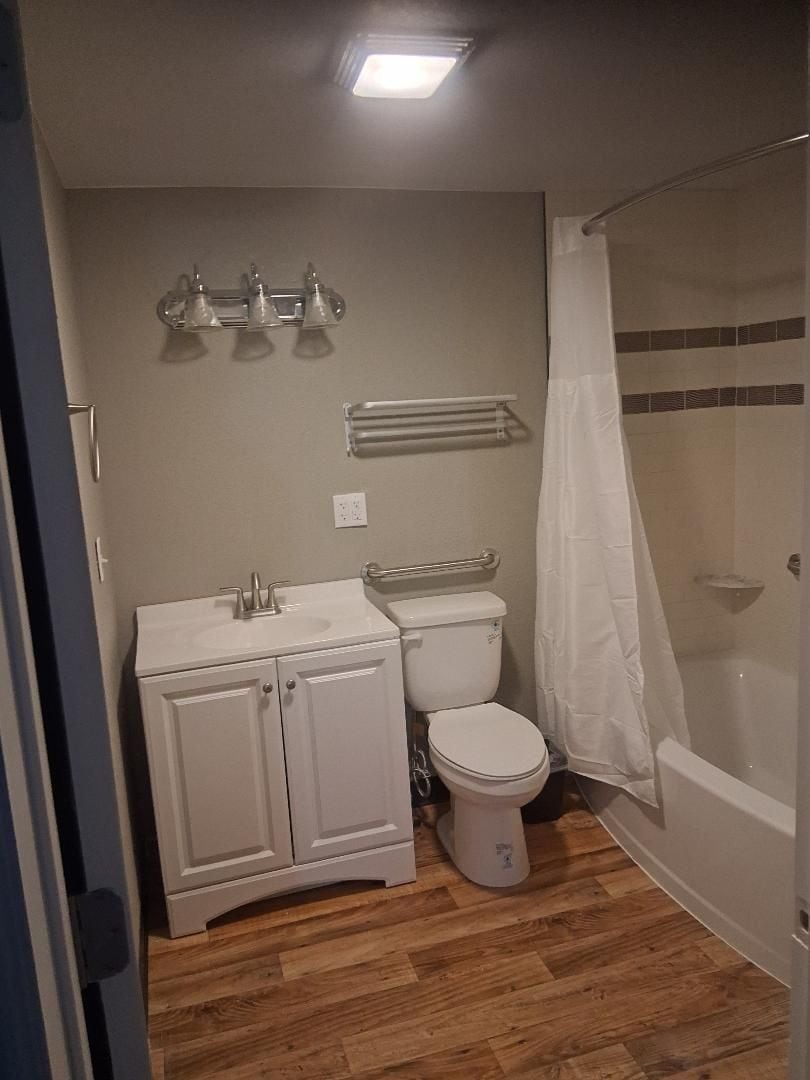 A bathroom with a toilet, sink, and shower area.