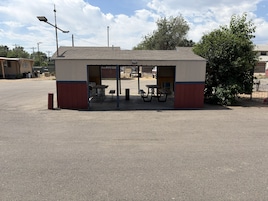 Una pequeña estructura al aire libre con una mesa y bancos, probablemente un espacio de descanso o quiosco.