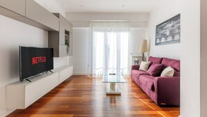 A modern living room with a flat-screen TV, a glass coffee table, and a purple sofa. - 15 Minutes Walk From Vatican Museums (Roma)
