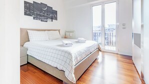 A modern bedroom with a large bed, a nightstand, and a cityscape artwork on the wall. - 15 Minutes Walk From Vatican Museums (Roma)