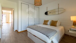 Ein Schlafzimmer mit einem Bett, einer Hängelampe, einer Surfbrett-Dekoration und einem Kleiderschrank.