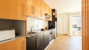 Eine moderne Küche mit Holzausstattung, Edelstahlgeräten und einem großen Fenster.