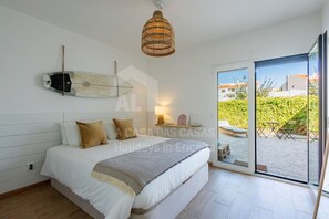 A bedroom with a bed, a hanging light fixture, a window, and a view of the outside. - Valentin House by Acasadascasas (Mafra)