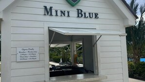 Un edificio blanco con un letrero que dice "Mini Blue" y un logotipo encima.