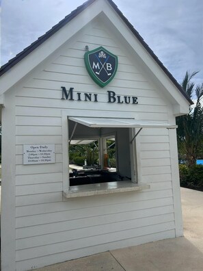 A white building with a sign reading "Mini Blue" and a logo above it. - 5 Mins Walk to Beach-Gated-Bahamar-Cable Beach-1200 sqft (Nassau)
