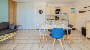 Un espacio habitable compacto con comedor, kitchenette y sofá.