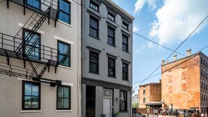 A multi-story building with a fire escape, large windows, and a brick facade. - OTR by TQL+Smart TVs+King Bed+Wifi+Sleeps 3+1st Fl (Cincinnati)