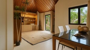 A modern dining area with a glass table, white chairs, and a wooden ceiling. - TULUM Koh Samui (Koh Samui)