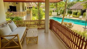 A covered outdoor area with a pool, wooden furniture, and a bamboo fence. - TULUM Koh Samui (Koh Samui)