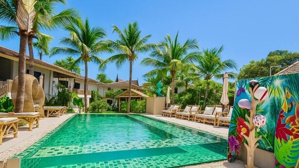 A swimming pool with tiled edges, surrounded by lounge chairs and palm trees. - TULUM Koh Samui (Koh Samui)