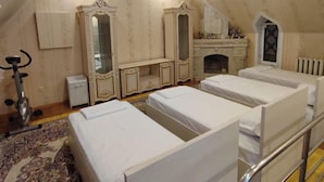 A bedroom with three beds, a mirror, a dresser, and a small exercise bike. - DDS Hostel (Tashkent)