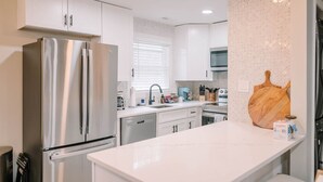 A modern kitchen with stainless steel appliances, white cabinetry, and a marble countertop. - The Central Nest-3bd/1bth -2.5miles from Casino (Danville)