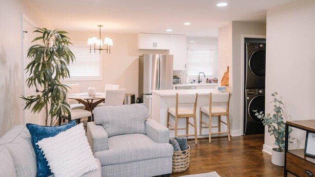 A modern kitchen with white cabinets, a built-in refrigerator, and a dining area with a table and chairs. - The Central Nest-3bd/1bth -2.5miles from Casino (Danville)