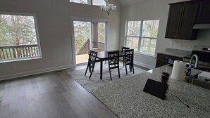 A spacious kitchen with large windows, a dining area, and a view of the outdoors.
