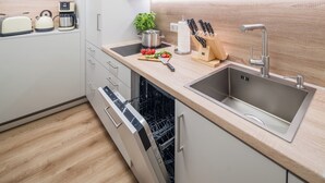 A modern kitchen with a dishwasher, sink, and various appliances. - Fewo7Home New opening apartment at the university (Oldenburg)