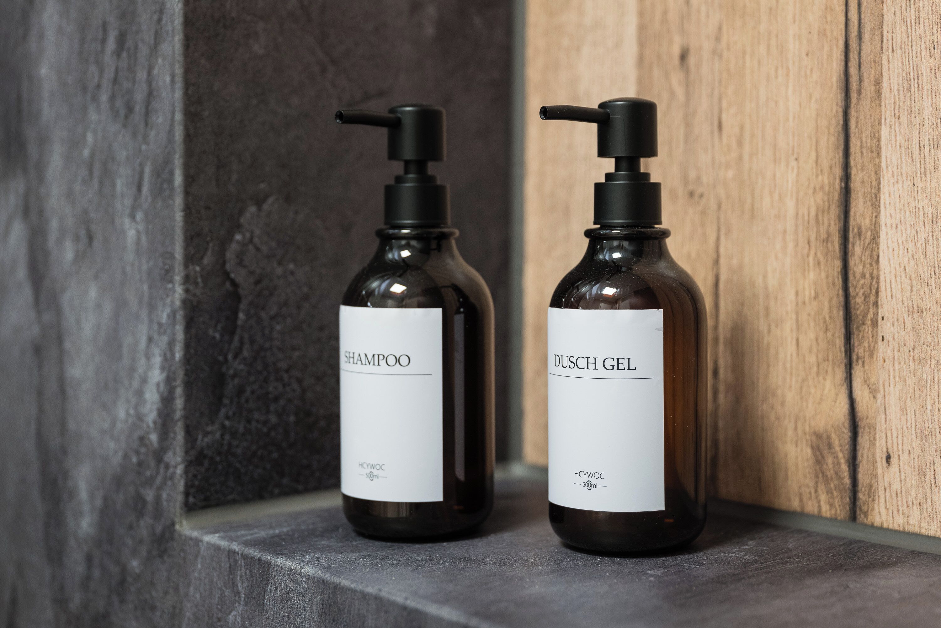 Two bottles of shampoo and gel on a shelf.