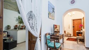 Ein gemütliches Interieur mit einem Holzesstisch, Stühlen und einer kleinen Küchenzeile.